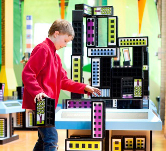 boy in red shirt building with blocks in tumble zone