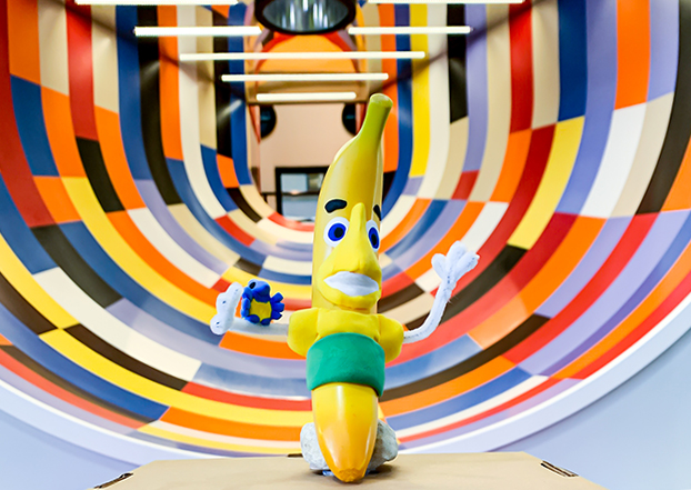 Miniature Sunny The Banana and Breezy The Blue Jay figures in front of a multi-coloured Illusion Tunnel slide